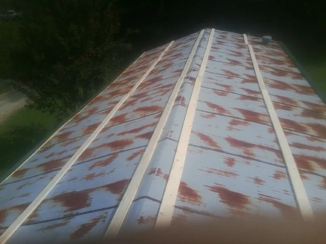 Rusted metal roof panels with new wood purlins before replacement — Storm Damage Roof Repair in Orange Springs by Roofing Brothers