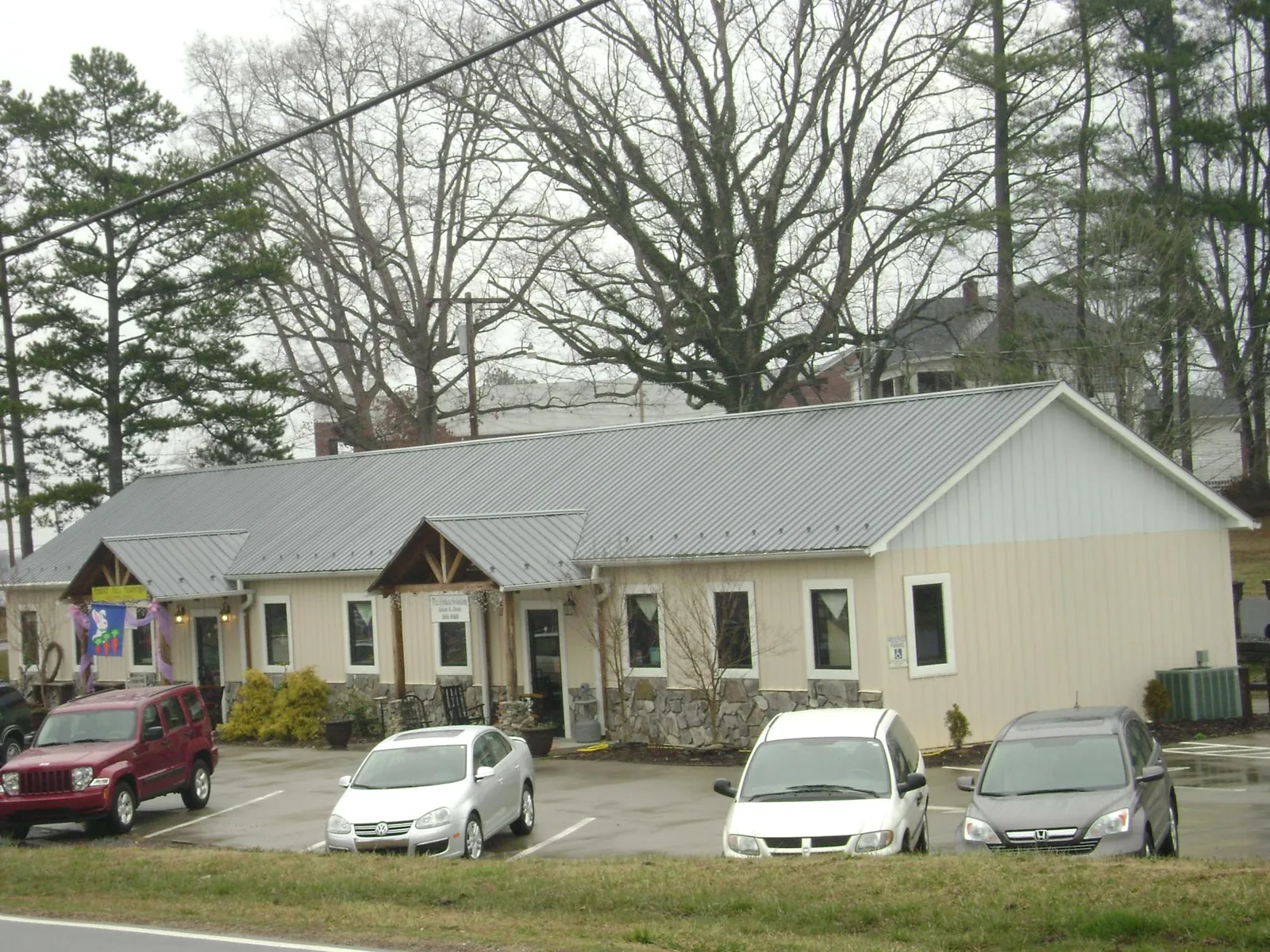 Gray metal roof with timber entry brackets on a small commercial building in Orange Springs